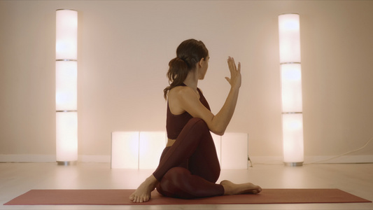 坐在瑜伽垫上做脊椎曲折姿势的女人视频