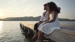 夫妇坐在湖中码头上看夕阳23秒视频