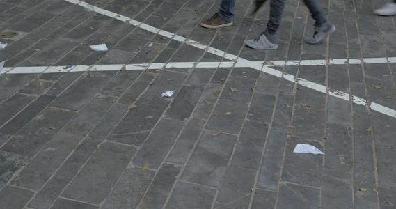在街上用纸垃圾走在街上的人脚下视频