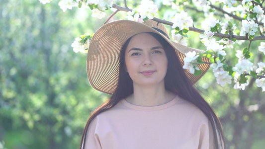 年轻女子欣赏着盛开的苹果花视频