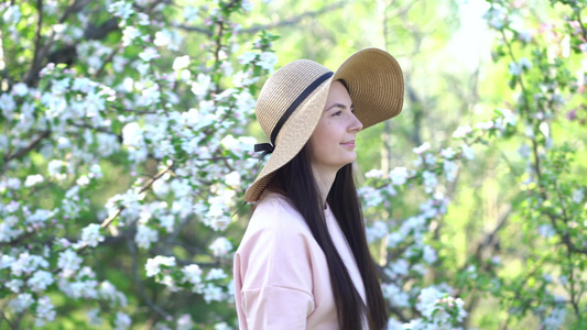 美丽的年轻女子,享受着盛开的苹果花春果园视频