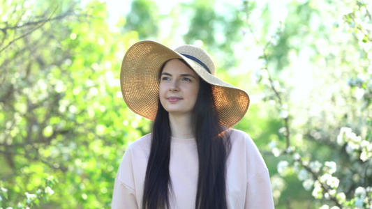 美丽的年轻女子,享受着盛开的苹果花春果园视频