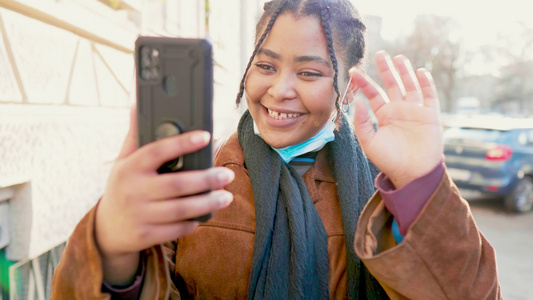 面罩微笑的年轻女子在意大利街头进行视频通话视频