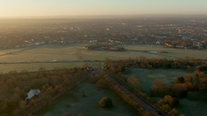 英国伦敦日落时分穿过田野的道路上的交通26秒视频