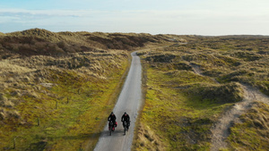 荷兰弗里斯兰内斯土路上骑自行车的男女27秒视频