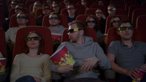 坐在电影院看3D和吃爆米花的年轻人11秒视频