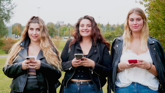 意大利三名在户外带智能手机的年轻女性的画像视频