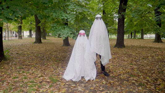 秋天公园里穿着幽灵服装的女孩和十几岁的男孩视频