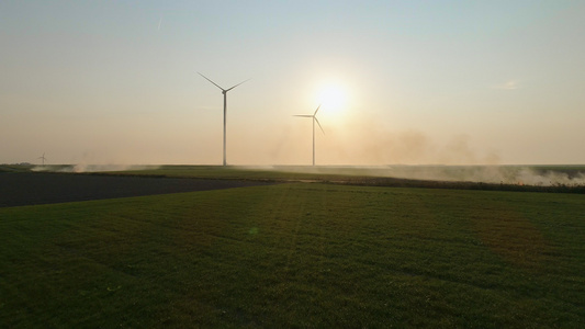 日落时在田野里的风力涡轮机视频