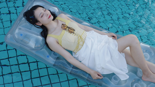 躺在泳池浮床上休息的女生视频