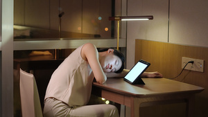 夜晚女人困倦趴在桌上休息25秒视频
