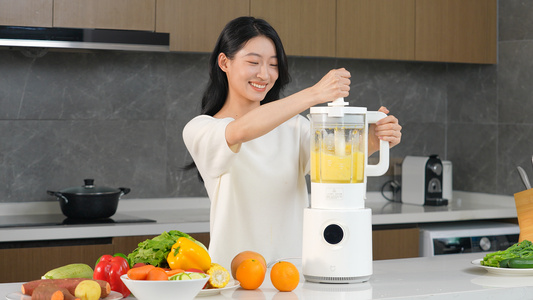 女人使用榨汁机榨取橙汁视频