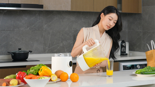 女人倒取榨汁机里的橙汁视频