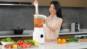 女人使用榨汁机榨取果蔬汁64秒视频