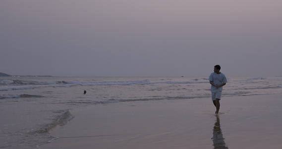 8K傍晚海边沙滩上漫步的男青年视频
