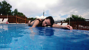 少女在豪华游泳池边缘放松慢动作22秒视频