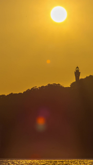 太阳从海岛灯塔上落下夕阳西下延时视频空镜头16秒视频