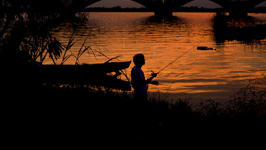 在夕阳江水中钓鱼的人[野钓]视频