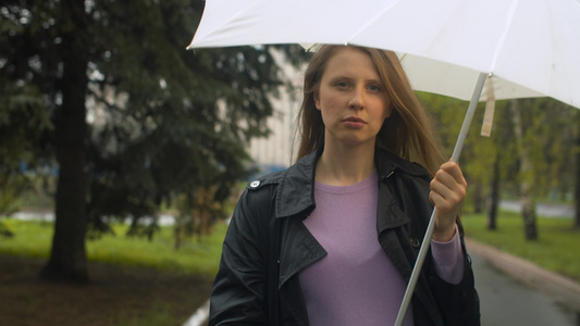 在雨伞下行走的成年年轻妇女视频