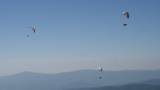 3个滑翔伞在清蓝的天空中飞行视频