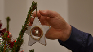 男人把心形的铃铛挂在天然松树圣诞树17秒视频