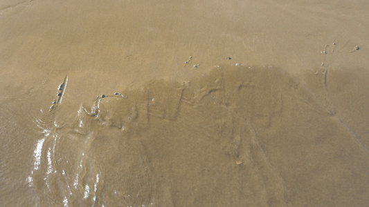 海浪冲洗 隆登在沙滩上写着视频