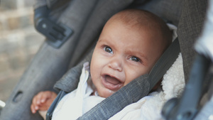 在一辆灰色婴儿车里哭着的婴儿悲伤地看着摄影机7秒视频