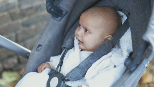 坐在人行道上一辆灰色的婴儿车里带着忧伤的表情视频