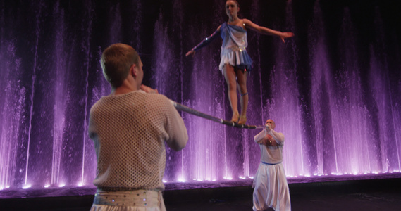 一群杂耍演员用电杆对抗多彩喷泉视频