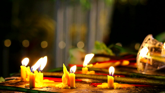 蜡烛上点着火,以敬拜Buddha勋爵,并模糊许多蜡烛背景视频