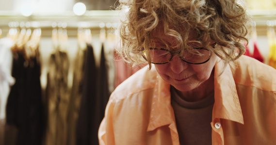 女店主在一家老式服装店戴眼镜折叠衬衫视频
