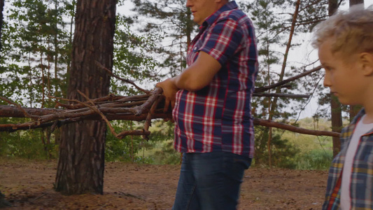 儿子和父亲带着木柴在森林里伐木视频