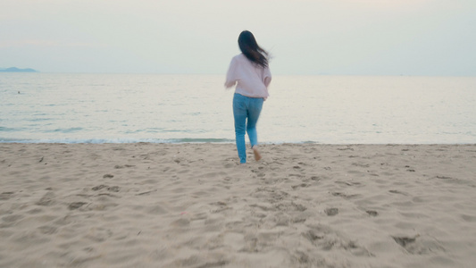 幸福的女子在热带海滩享受暑假赤脚奔向海洋双臂张开视频