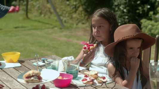 两个女孩坐在花园桌旁吃蛋糕视频