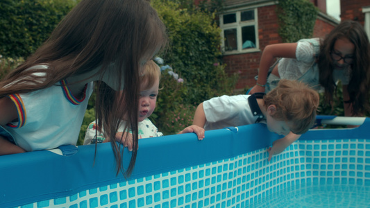 一群年幼的孩子在花园里的戏水池玩耍视频