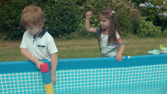 一群年幼的孩子在花园里的戏水池玩耍视频