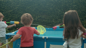 男人和年幼的孩子在花园里的戏水池玩耍8秒视频