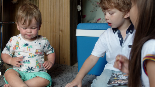 两个年轻的男孩和女孩坐在地板上吃炸薯条视频