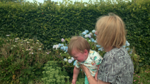 祖母站在花园里抱着她年幼的孙子15秒视频