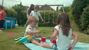 女孩和小男孩坐在花园里的毯子上玩积木6秒视频