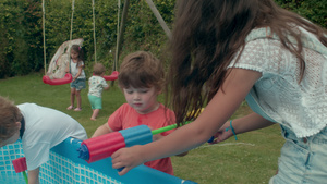 一群孩子在花园里的戏水池里玩喷枪17秒视频