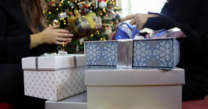 坐在地板上，把礼物放在圣诞树下23秒视频