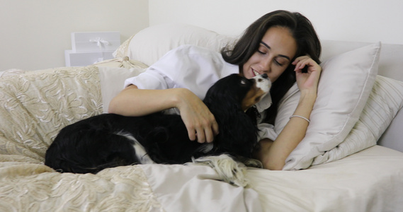 女人和她床上的一只宠物狗视频