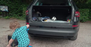 男孩把玩具放进汽车后备箱6秒视频
