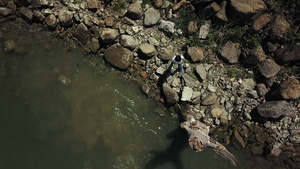 空中无人机拍摄的女孩站在意大利翁布里亚湖的岩石岸边为她的狗扔棍子18秒视频