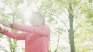 身体健康的女孩在公园中伸展她的手臂和颈部,在跑步前将运动加热起来30秒视频