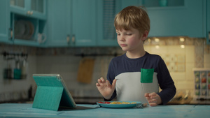 小男孩吃西红柿炒鸡蛋在家看平板电脑26秒视频