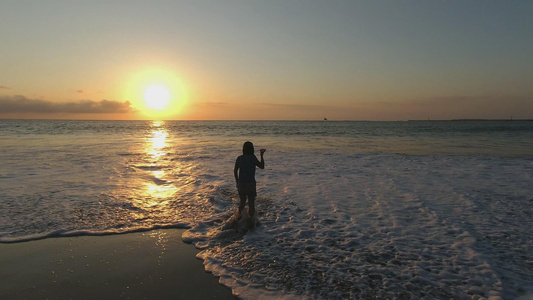 日落时分在海边玩水的人高清视频视频