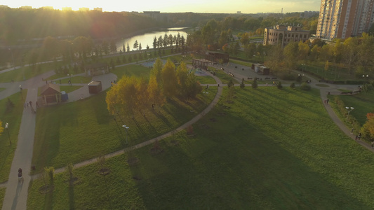 绿色城市公园秋天日落,空中观光,无人驾驶飞机正向前飞去视频