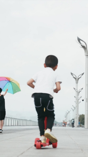 小孩在广场上玩滑板车升格拍摄36秒视频